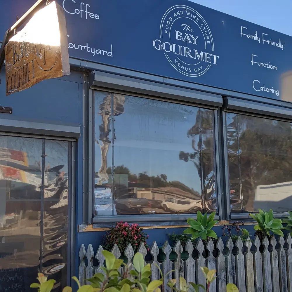 facade of the bay gourmet store with signage saying coffee, courtyard, family friendly, function and catering