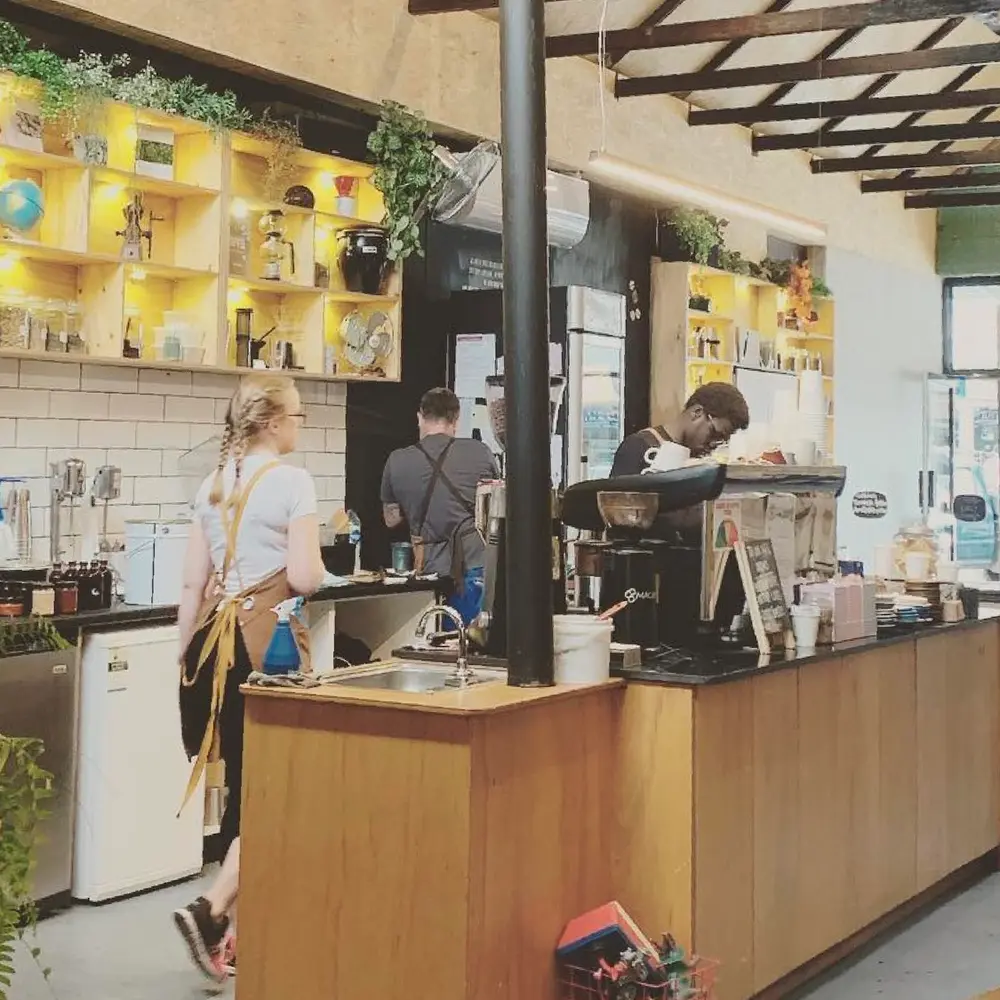 View of the interior space at Folks Coffee with some baristas working at the counter